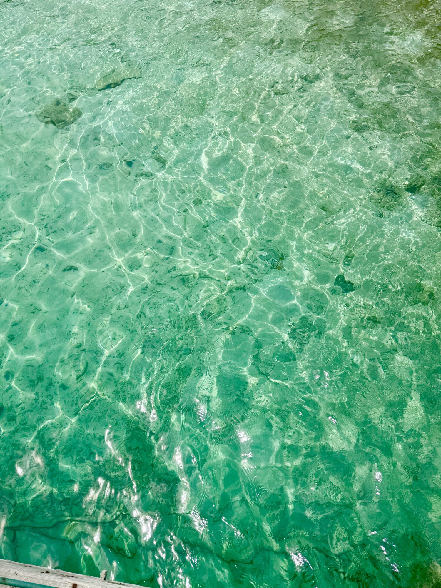 Crystal-clear shallow green water with light ripples