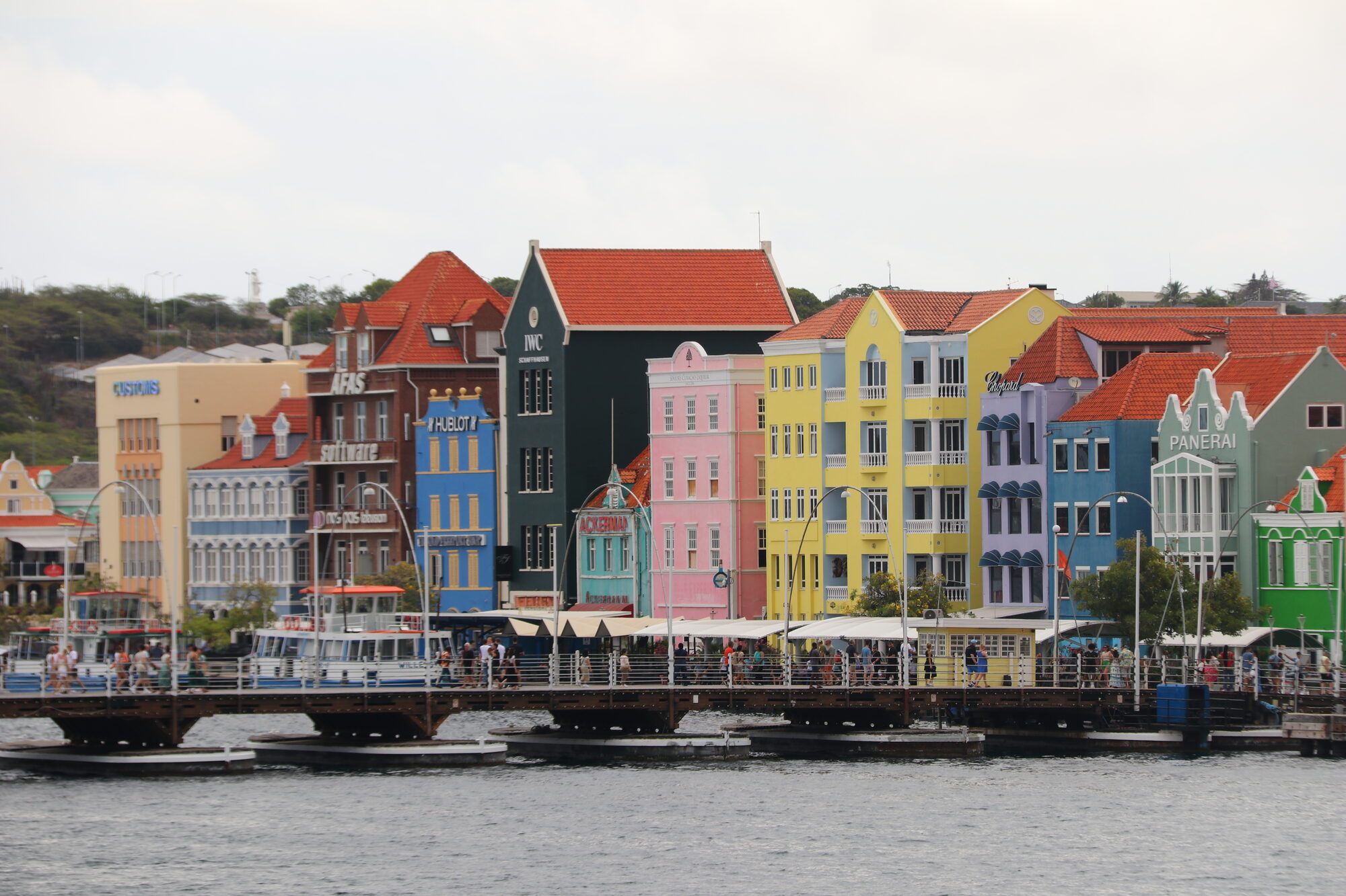 The painted Handelskade waterfront of Willemstad with the pontoon bridge