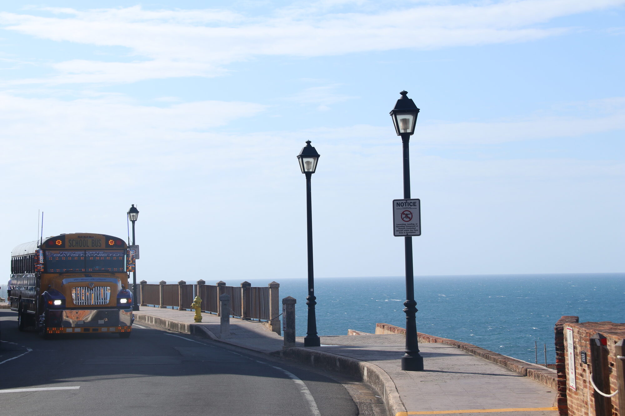 Street lamps along the sea road with a yellow bus