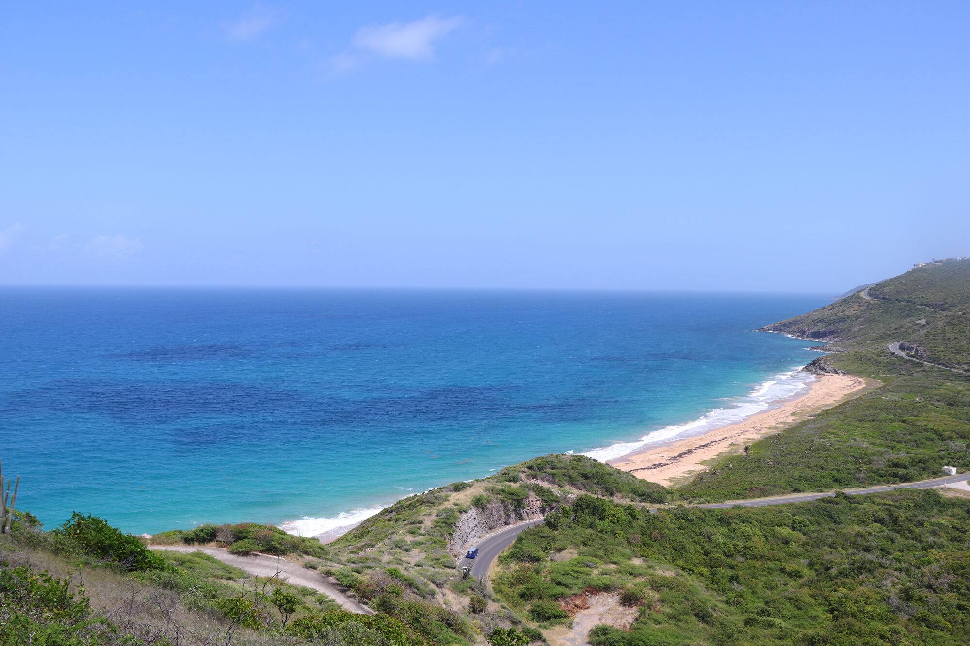 Wild coastline with turquoise water and green hills