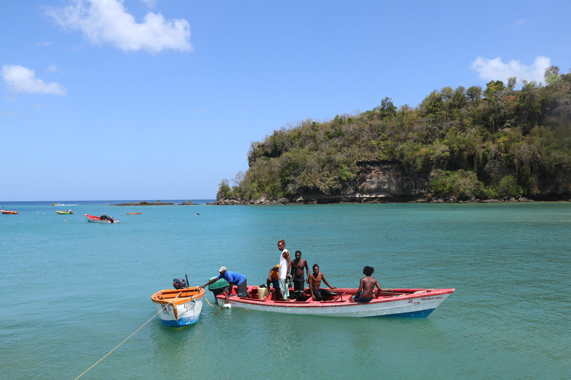 Fishermen in a red boat on teal water
